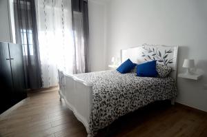 una camera bianca con letto e cuscini blu di Il Rifugio dei Briganti a Crispiano