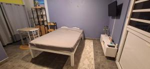 a small hospital room with a bed and a tv at Studio au Vert Pré in Le Robert
