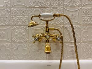 a brass shower head in a bathroom next to a tub at La Villa Kara in Romans-sur-Isère +44 photos