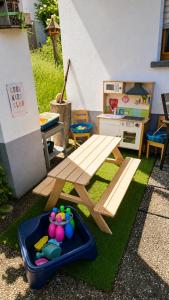 a wooden picnic table and a play set on the grass at Ferienwohnung Panoramablick Bermersbach in Forbach