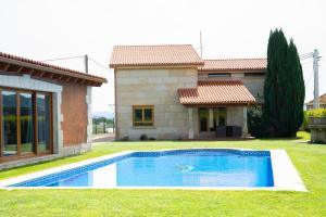 a swimming pool in front of a house at Welcome Villa O Sidrón in Alba
