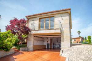 a house with a balcony and a driveway at Welcome Villa O Sidrón in Alba