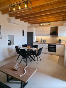 a living room with a table and chairs and a kitchen at Villa Natural View in Moutsoúna