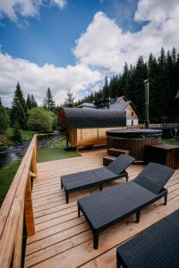 a wooden deck with benches and tables on it at Chata Františkov in Kvilda