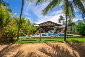 a resort with a hammock and a pool at Casa Caroá - Chalé 2 in Japaratinga