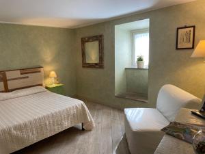 a bedroom with a bed and a couch and a window at Residenza La Gemma in Subiaco