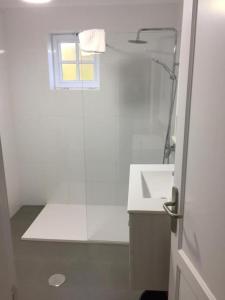 a white bathroom with a shower and a sink at Apartamentos Finca Colon in Los Quemados +16 photos