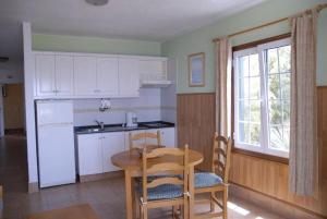 a kitchen with a table and chairs and a refrigerator at Apartamentos Finca Colon in Los Quemados