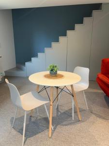 a table with two chairs and a potted plant on it at Sur côte en Dombes in Villette-sur-ain