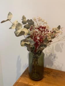 a vase with flowers in it sitting on a table at Sur côte en Dombes in Villette-sur-ain