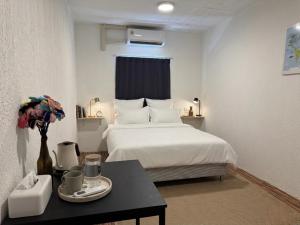 ein Hotelzimmer mit einem Bett und einem Tisch in der Unterkunft KINBOSHI Inn in Bangkok