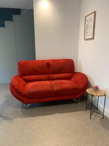a red couch in a room with a table at Sur côte en Dombes in Villette-sur-ain