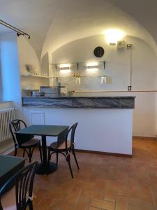 a dining room with a table and chairs and a kitchen at Hotel Villa Porta All'Arco in Volterra