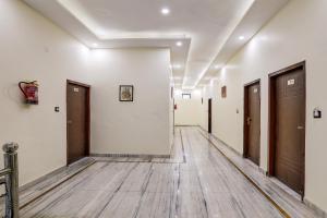 an empty hallway with doors and wooden floors at Super Hotel O Clock Tower Dehradun Formerly Dooncity Suites in Dehradun