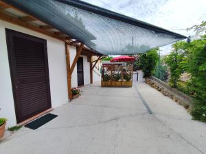 a garage with a covering on the side of a house at La Casina Procchio loc I Marmi in Procchio