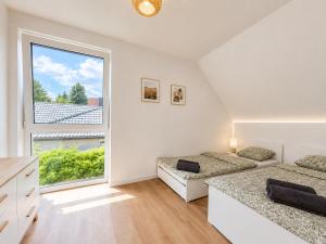 a bedroom with two beds and a large window at Lake House Szteklin in Szteklin