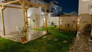 a backyard with a wooden pergola and a table at Salamina Urban Escape C in Paloúkia
