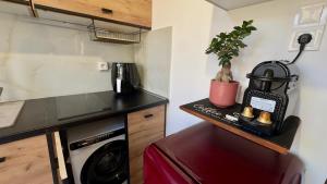 a small kitchen with a black counter and a dishwasher at Salamina Urban Escape C in Paloúkia