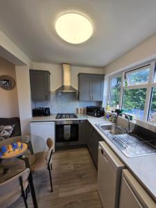 a kitchen with a sink and a table with a dining room at White Shelf Dartford House in Kent