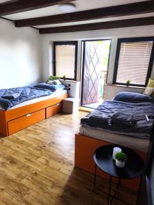a bedroom with two beds and a table and two windows at Chata Vrcov in Vrcov