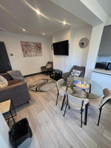a living room with a couch and a table and chairs at White Shelf Dartford House in Kent +5 photos