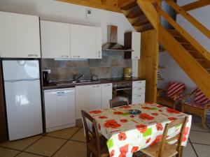 a kitchen with a table and a white refrigerator at Maison Gille in Nuits-Saint-Georges