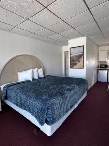 a bedroom with a large bed with a blue comforter at The Jetty Motel in Cape May +10 photos