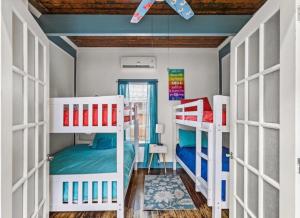 a room with two bunk beds and a ceiling at Blue Heron Cottage in Galveston