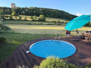a swimming pool with an umbrella and a table at Basel Landskron Haus in Leymen