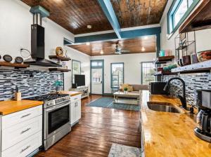 a kitchen with white cabinets and a stove top oven at Blue Heron Cottage in Galveston