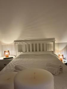 a bedroom with a white bed with two lamps at Leśna Stodoła in Siennica