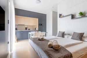 a bedroom with a large bed with towels on it at Aqua Rosa Tiszafüred 2 in Tiszafüred