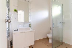 a white bathroom with a sink and a shower at Aqua Rosa Tiszafüred 2 in Tiszafüred