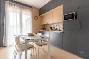 a kitchen with a white table and chairs and a window at Aqua Rosa Tiszafüred 2 in Tiszafüred