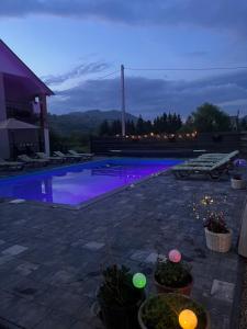 a swimming pool at night with purple lights at котедж петриківка З червня басейн з підігрівом 10 на 5 метрів in Slavske +87 photos