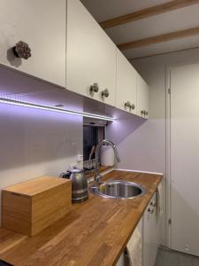 a kitchen with a sink and a wooden counter top at Leśna Stodoła in Siennica
