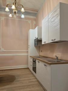 a kitchen with white cabinets and a sink at Zucca s home in Baveno