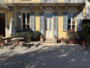 a yellow house with a table and an umbrella at Zucca s home in Baveno