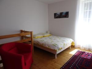 a small bedroom with a bed and a chair at Maison Gille in Nuits-Saint-Georges