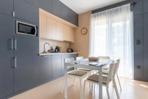 a kitchen with a white table and chairs and a window at Aqua Rosa Tiszafüred 2 in Tiszafüred