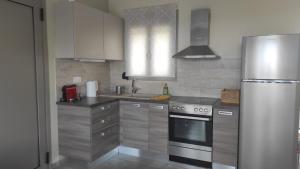 a kitchen with stainless steel appliances and a refrigerator at Villa Aias- Private Olive Grove Retreat in Plakias