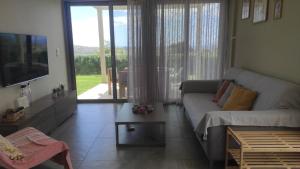 a living room with a couch and a large window at Villa Aias- Private Olive Grove Retreat in Plakias