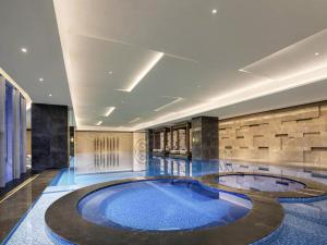 a large swimming pool in the middle of a building at Pullman Huai'an in Huai'an