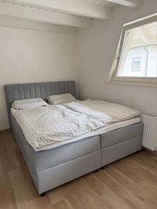 a bed in a white room with a window at Boardinghouse Rheinfelden 4 in Rheinfelden