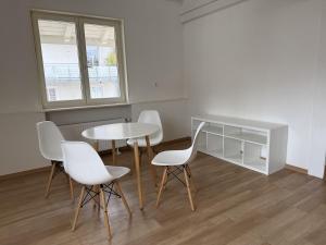 a dining room with a table and white chairs at Boardinghouse Rheinfelden 4 in Rheinfelden
