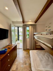 a bedroom with a bed and a flat screen tv at Verdaad Mansion in La Libertad