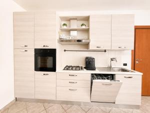a kitchen with white cabinets and a sink at Stile e comfort! in Trecate