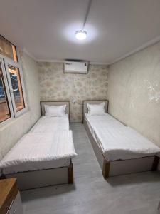 two beds in a small room at Noor house hostel in Fergana