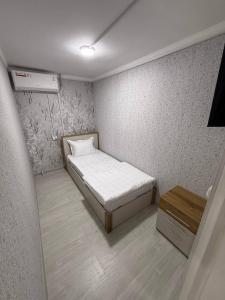 a small room with a bed and a table at Noor house hostel in Fergana