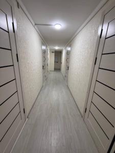 a long hallway with lockers in a building with a hallway at Noor house hostel in Fergana +1 photo